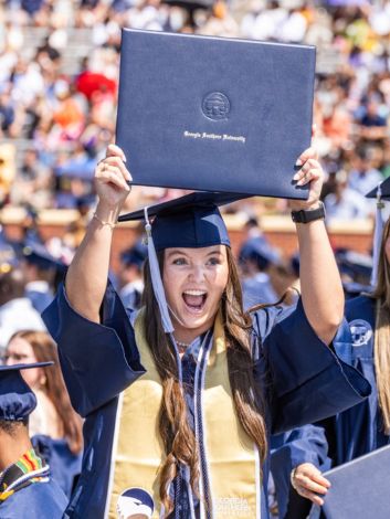 Georgia Southern Student holding up diploma holder