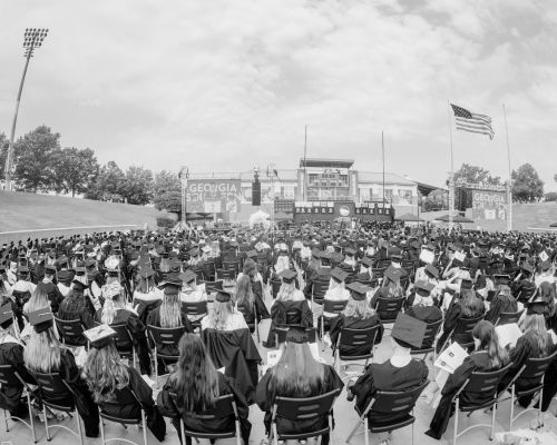 Black and white graduation photo of graudation class in seats