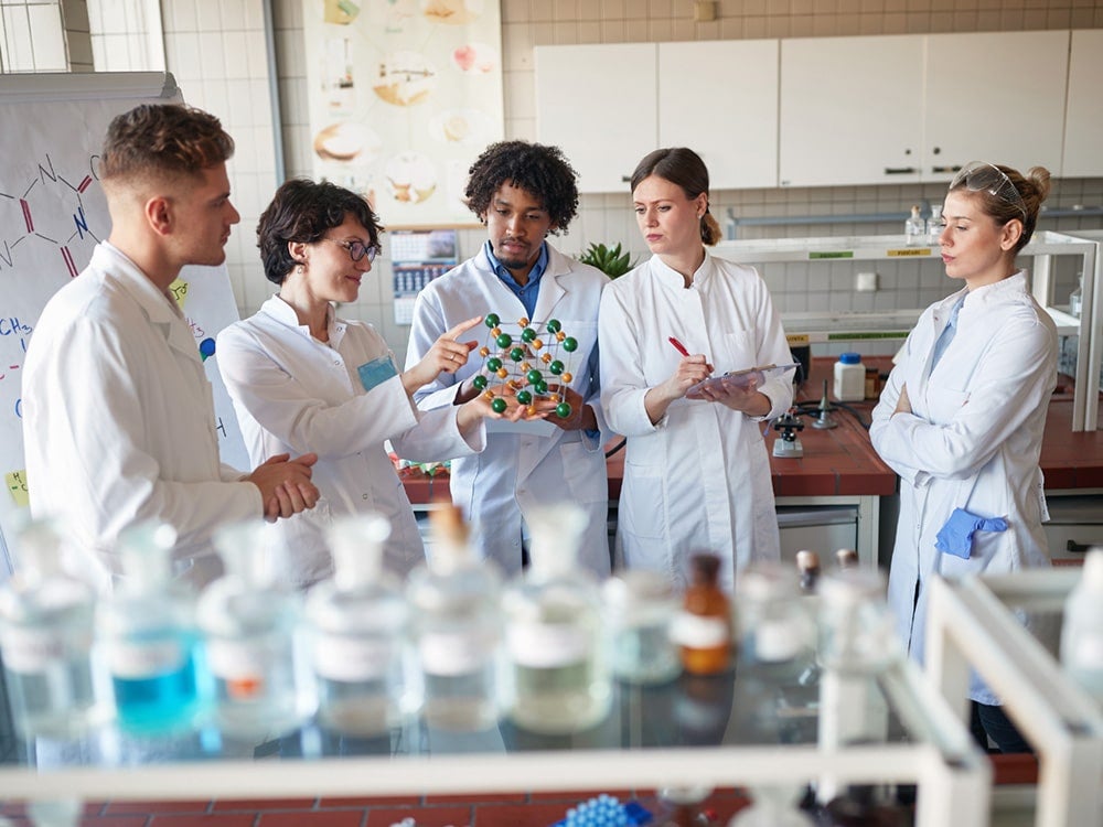 Group of Georgia Southern students speaking with a faculty member in a laboratory setting.