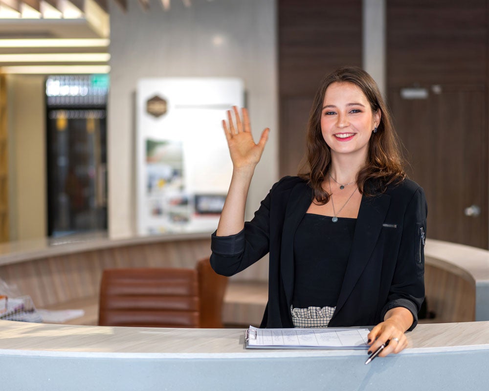 A student from Georgia Southern's B.S. in Recreation and Tourism Management program stands behind a hotel desk during an internship placement