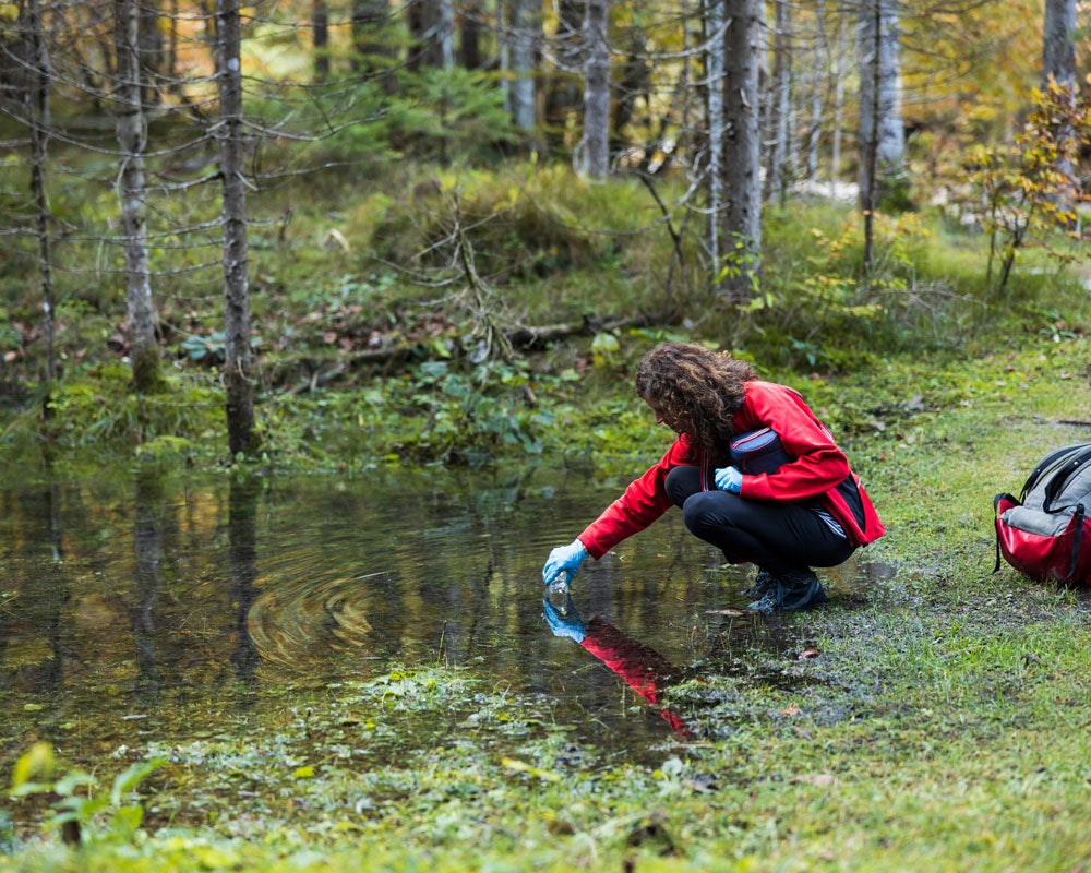 Participating in research, a student from Georgia Southern's B.S. in Recreation and Tourism Management program collects pond water samples