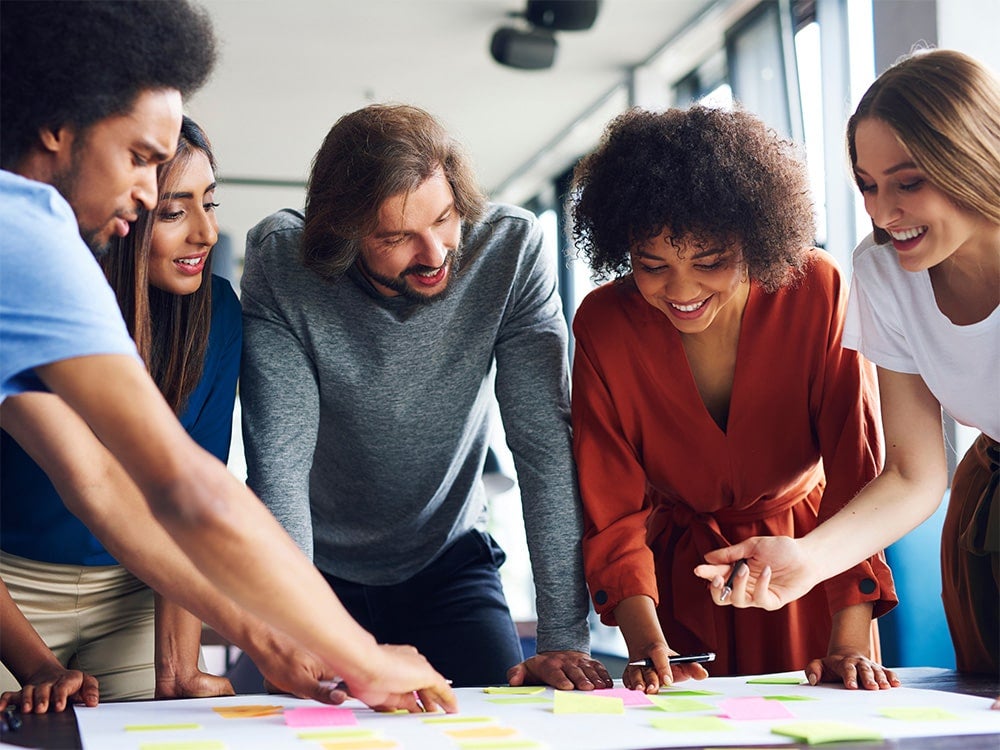 A group of Georgia Southern's M.Ed. in School Counseling program examines ideas jotted down on multicolored sticky notes