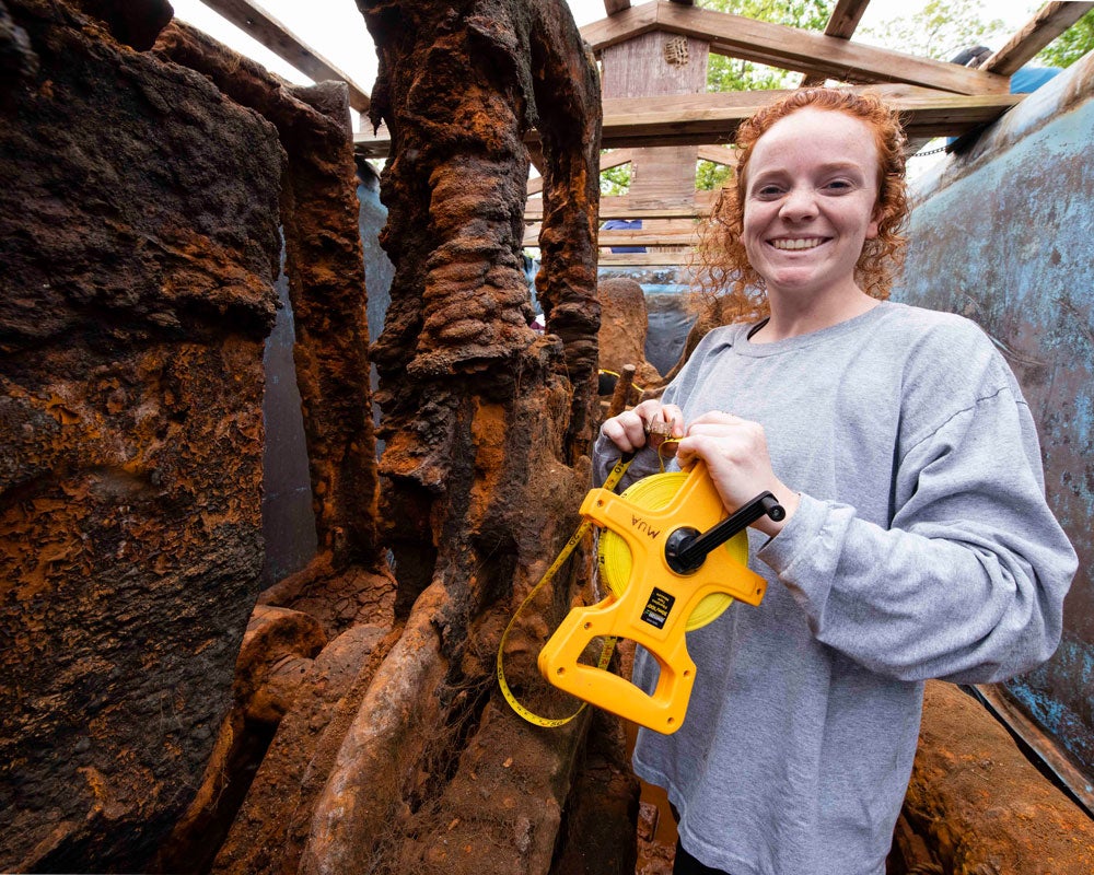 Student measuring historic objects found.