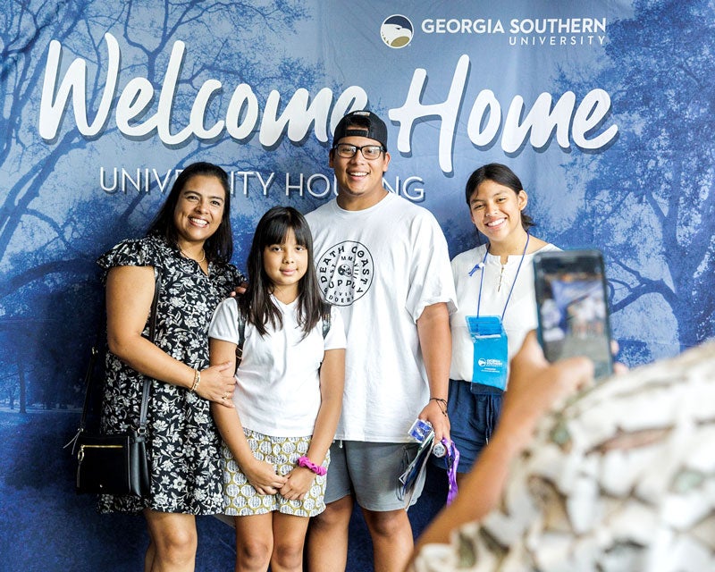 Georgia Southern student with their family posing for picture on campus.