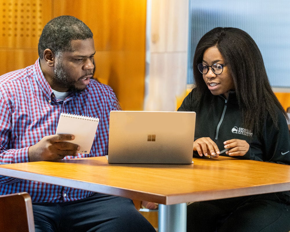 Georgia Southern student and parent with laptop at table.