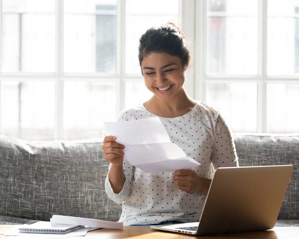 Happy adult woman holding paper reading good news college scholarship received.