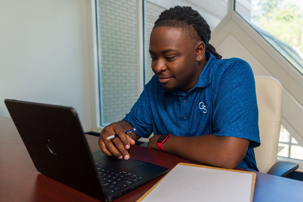 GS Online first-year student with laptop.